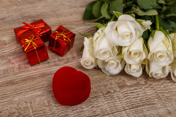 Roses with heart engagement box. Love design on wood background. Valentines day concept. Fresh natural flowers with gift boxes. Wooden rustic board.