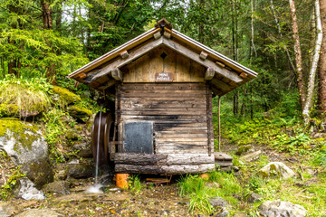 Fototapeta na wymiar Kleine Wassermühle mit Antriebsrad im Wald