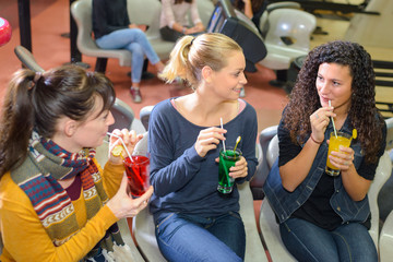 Women sipping drinks through straws