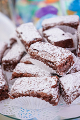 Brownie with glazed sugar in the top, on a white table on a white background.