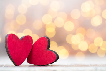 Two red hearts the wooden background.