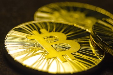 Macro view of shiny coins with Bitcoin symbol on dark background