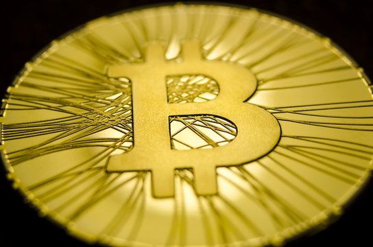 Macro view of shiny coins with Bitcoin symbol on dark background
