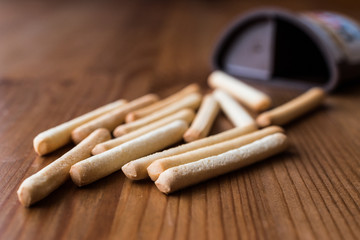Grissini with Chocolate cream on wooden surface.