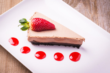 Chocolate cake slice with strawberry slice and topping