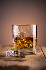 Glass of whiskey on wooden table, close-up