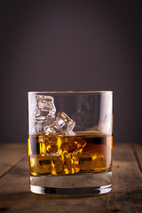 Glass of whiskey on wooden table