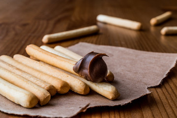 Grissini with Chocolate cream on wooden surface.
