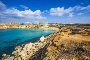 Ghajn Tuffieha, Malta - Panoramic skyline view of Golden Bay, Malta's most beautiful sandy beach on a nice summer day with blue sky and clouds
