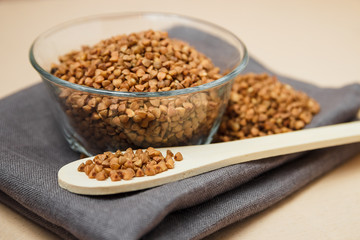 Buckwheat groats in bowl and wooden spoon