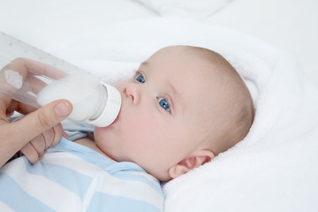 Mother feeding baby from bottle, closeup