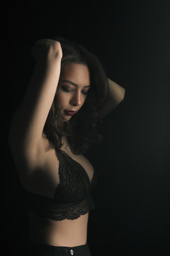 Sensual woman in sexy lace bra at the dark studio
