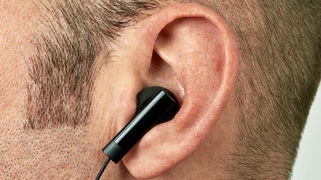 Ear with black earphone dancing vibrating and jumping to the music