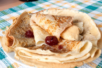 On the plate are pancakes with strawberry jam