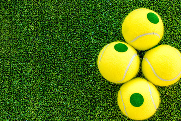 Naklejka premium tennis ball on green background top view mock up