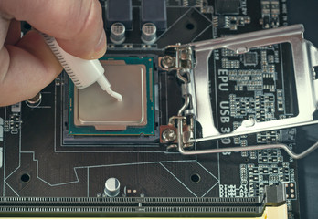 Applying thermal paste during CPU installation close up in the motherboard