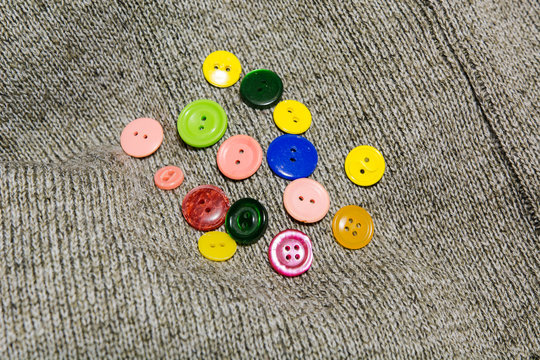 collection of various button of sewing on shert lie, a woolen jacket