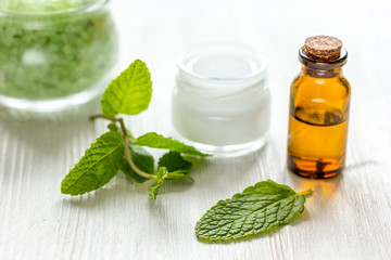 organic cosmetics with herbal extracts of mint on wooden background