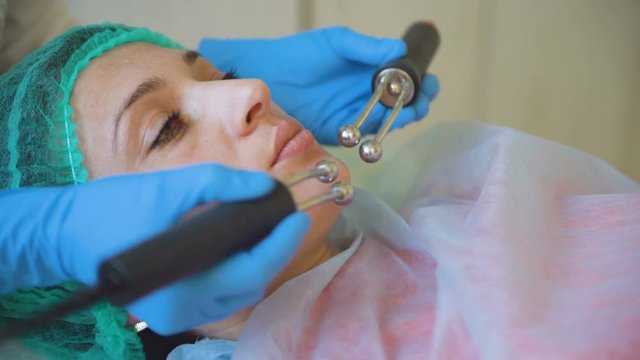 Cosmetology doctor female makes treatment procedure her patient in medical center closeup