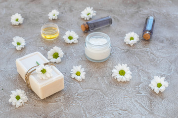 Fototapeta na wymiar organic cosmetics with camomile on stone background