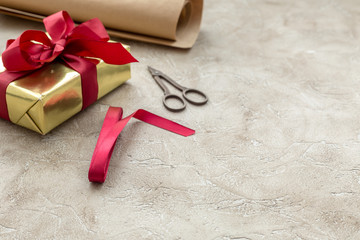 wrapping gifts in box for holiday on stone background