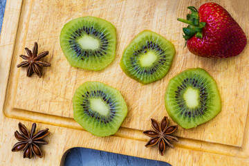 Kiwi fruit cut in slices on wooden cutting board