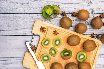 Kiwi fruit cut in slices on wooden cutting board