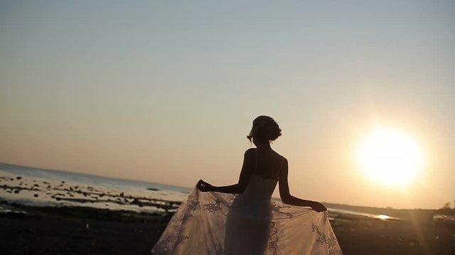 Bride walking on a evening beach slowmotion