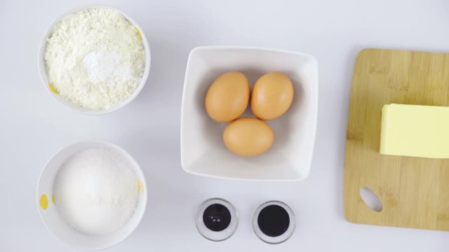 Flour, sugar, eggs and butter top view 4K