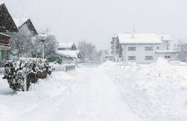 Heavy snowfall, poor visibility, blizzard, frost, winter. Alps, Austria. House, pines and fir-trees. Kirchberg.