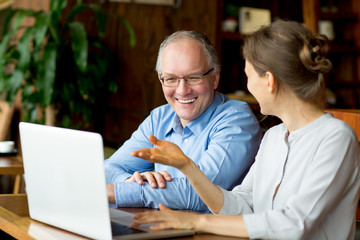 Two Smiling People Discussing Issues in Cafe