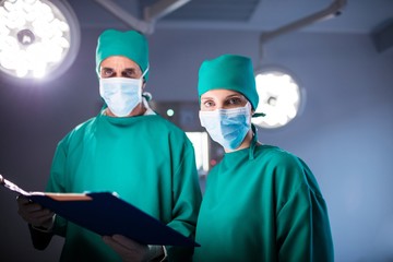 Fototapeta na wymiar Portrait of male and female surgeon holding a medical report