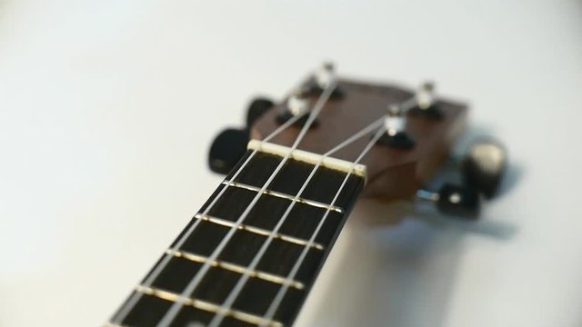Closeup ukulele guitar tracking from camera on the slider.