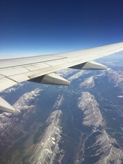 Obraz premium Aerial view of rocky mountains and airplane wing