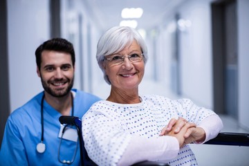 male doctor and female senior patient smiling  - obrazy, fototapety, plakaty