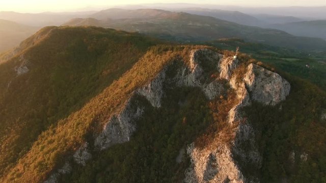 Aerial view, flight over a bautiful sunny mountain forest landscape with sunset