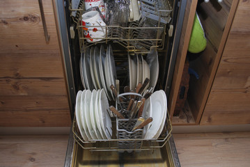 White dishes and cutlery in the dishwasher.