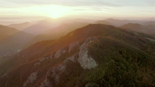 Aerial view, flight over a bautiful sunny mountain forest landscape with sunset