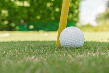 close up golf ball beside the hole