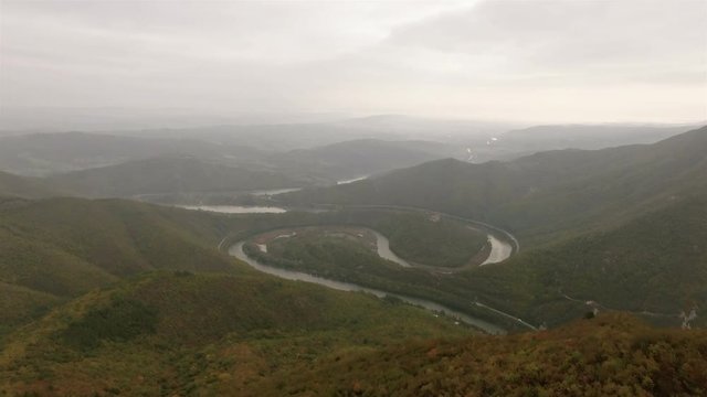 Aerial video of a meandering river under a mountin