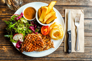 Grilled pork steak with vegetables salad and french fries