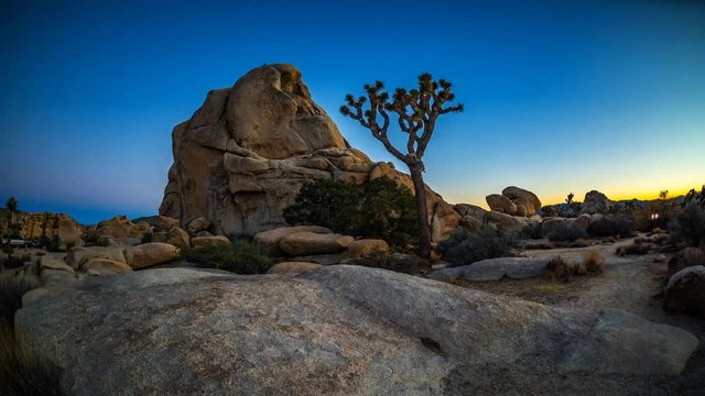 A time lapse of rock climbers climbing Old Woman Rock in Joshua Tree national park as the sun sets.