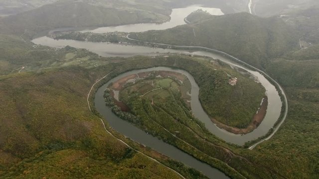 Aerial video of a meandering river under a mountin