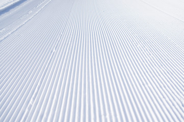 Slanting line of snowcat on white snow