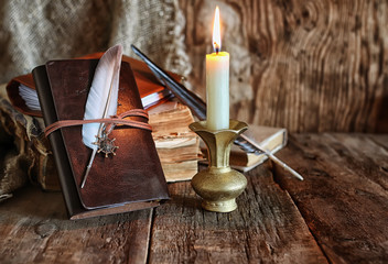 feather and book novel close to the a candle