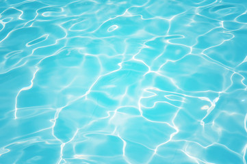 Fototapeta na wymiar Beautiful ripple water surface with sun reflection in swimming pool