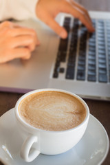 Woman working with laptop and hot coffee