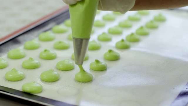 Process of making green macarons by woman hand