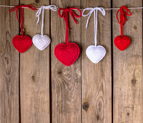 Knitting hearts on old wooden panel