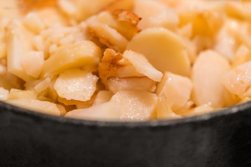 Roasted potatoes in a frying pan, background